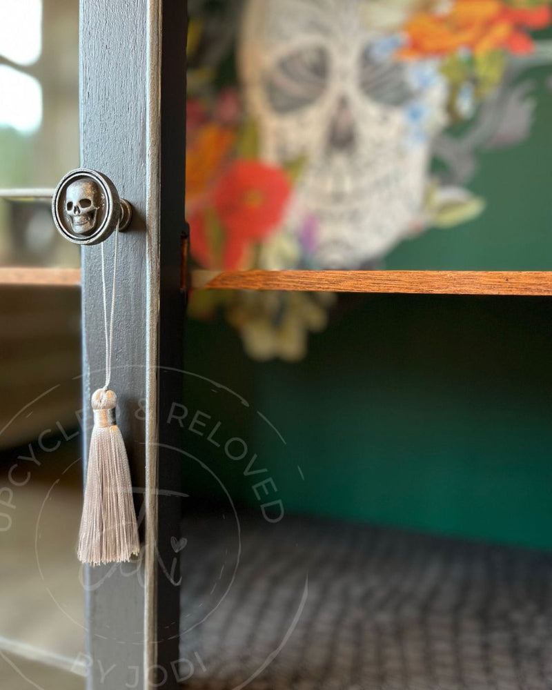 A custom rum cabinet with skull handles, Pressed Fern green interior and crocodile-print shelf lining, transformed by Upcycled & Reloved by Jodi.