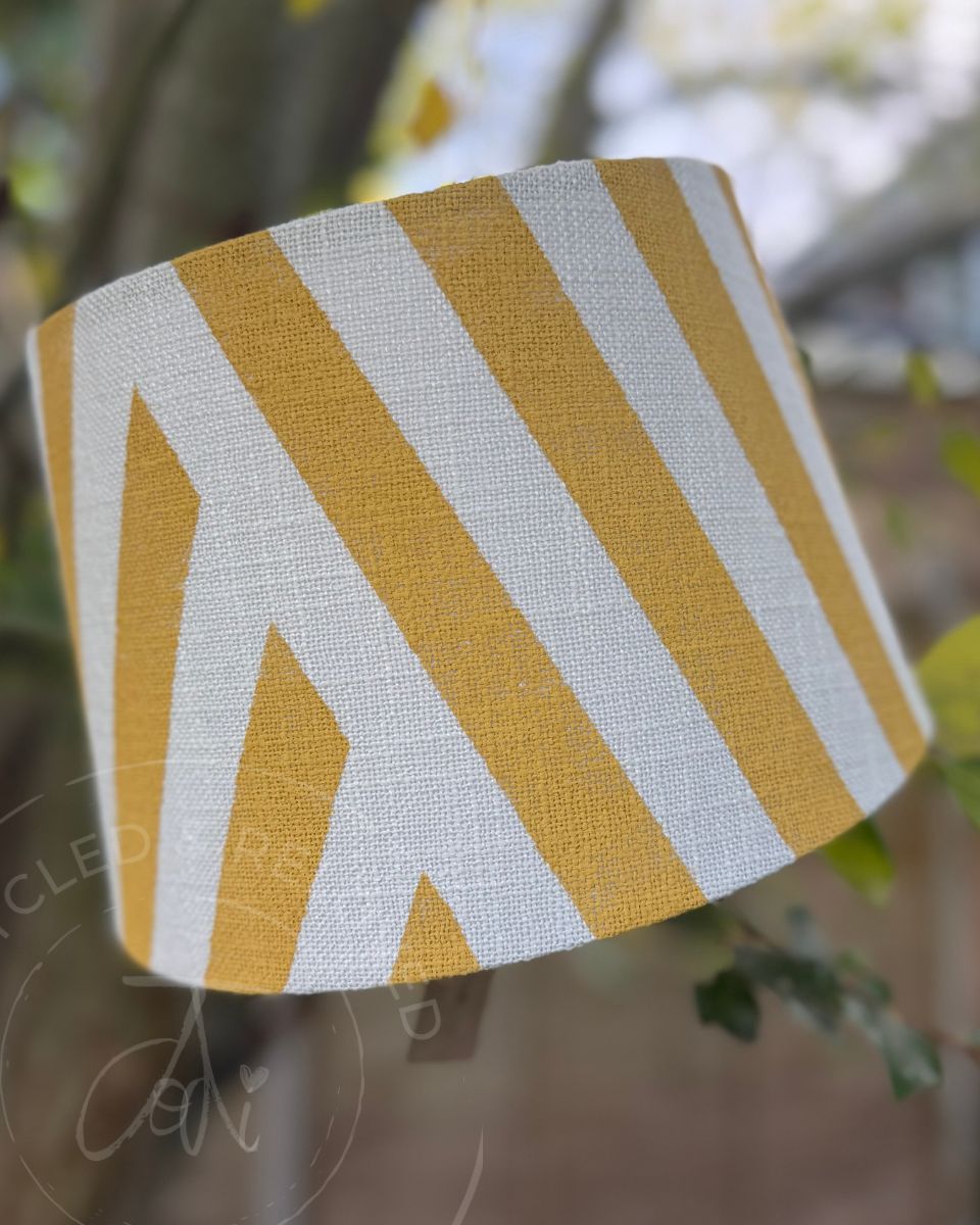 A white and yellow upcycled lampshade featuring neat yellow vertical stripes on a white background. Yellow and white stripy lampshade for UK delivery. Upcycled painted lampshade