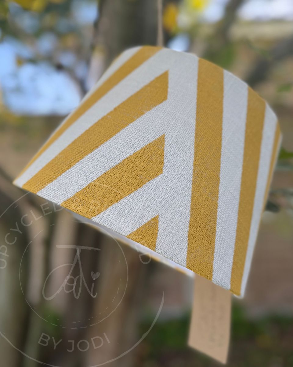 A white and yellow upcycled lampshade with  neat yellow stripes on a white background. Yellow and white stripy lampshade for UK delivery