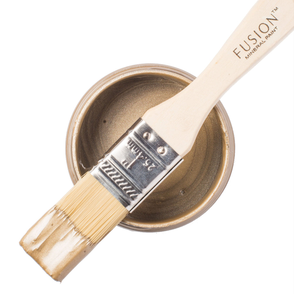 Fusion paintbrush with a container of Vintage Gold paint on a white background