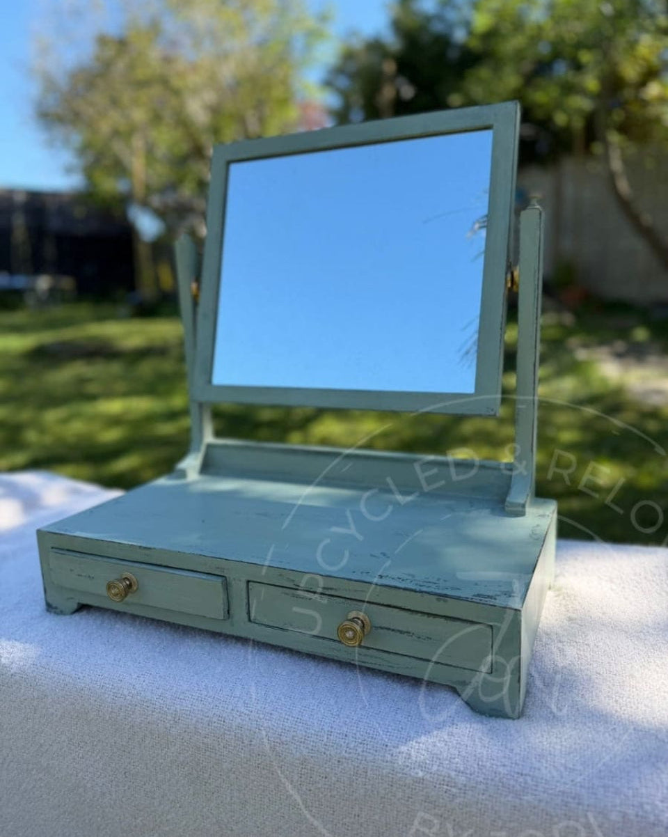 An upcycled small vintage dressing table mirror with two drawers is finished in soft greens from Fusion Mineral Paint with an aged, distressed effect. 
