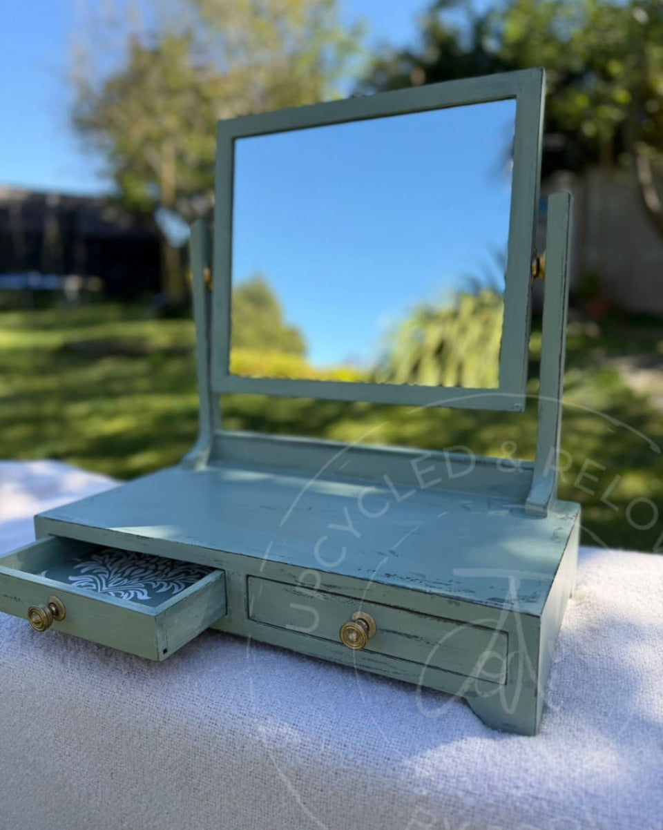 An upcycled small vintage dressing table mirror with two drawers is finished in soft greens from Fusion Mineral Paint with an aged, distressed effect. 