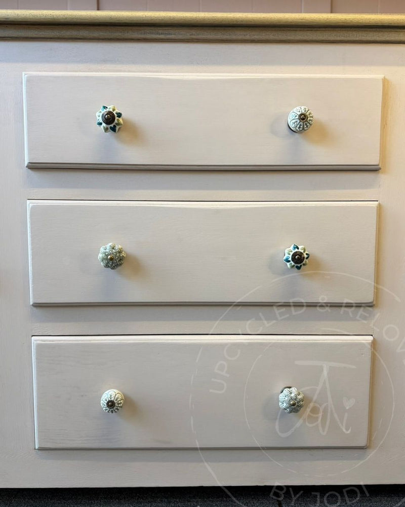 Three drawers painted in Fusion Mineral Paint Damask, with decorative ceramic knobs, shown in a close-up furniture detail shot. 