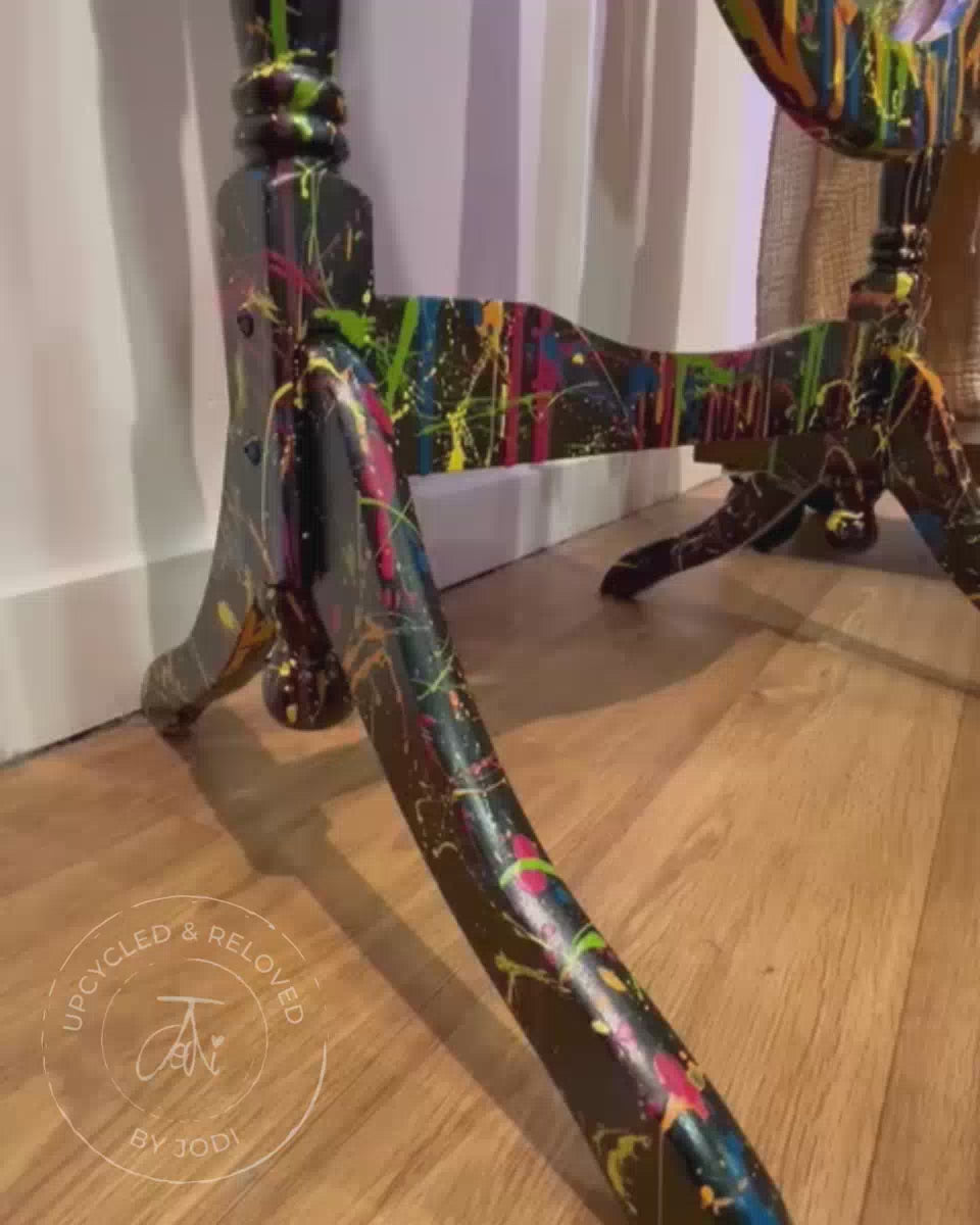 Short video showing the detail on a standing dressing mirror that has been upcycled and painted in black with splatters of brightly coloured paint